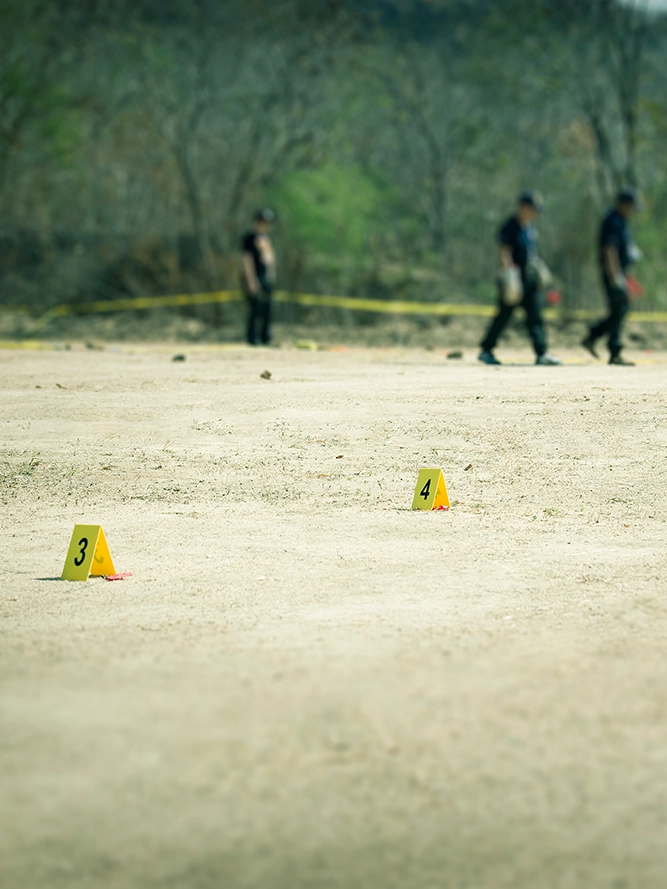 Crime scene in a dirt field with numbered plaques.
